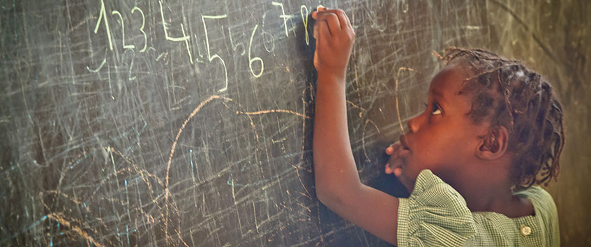 Girl writing on chalkboard